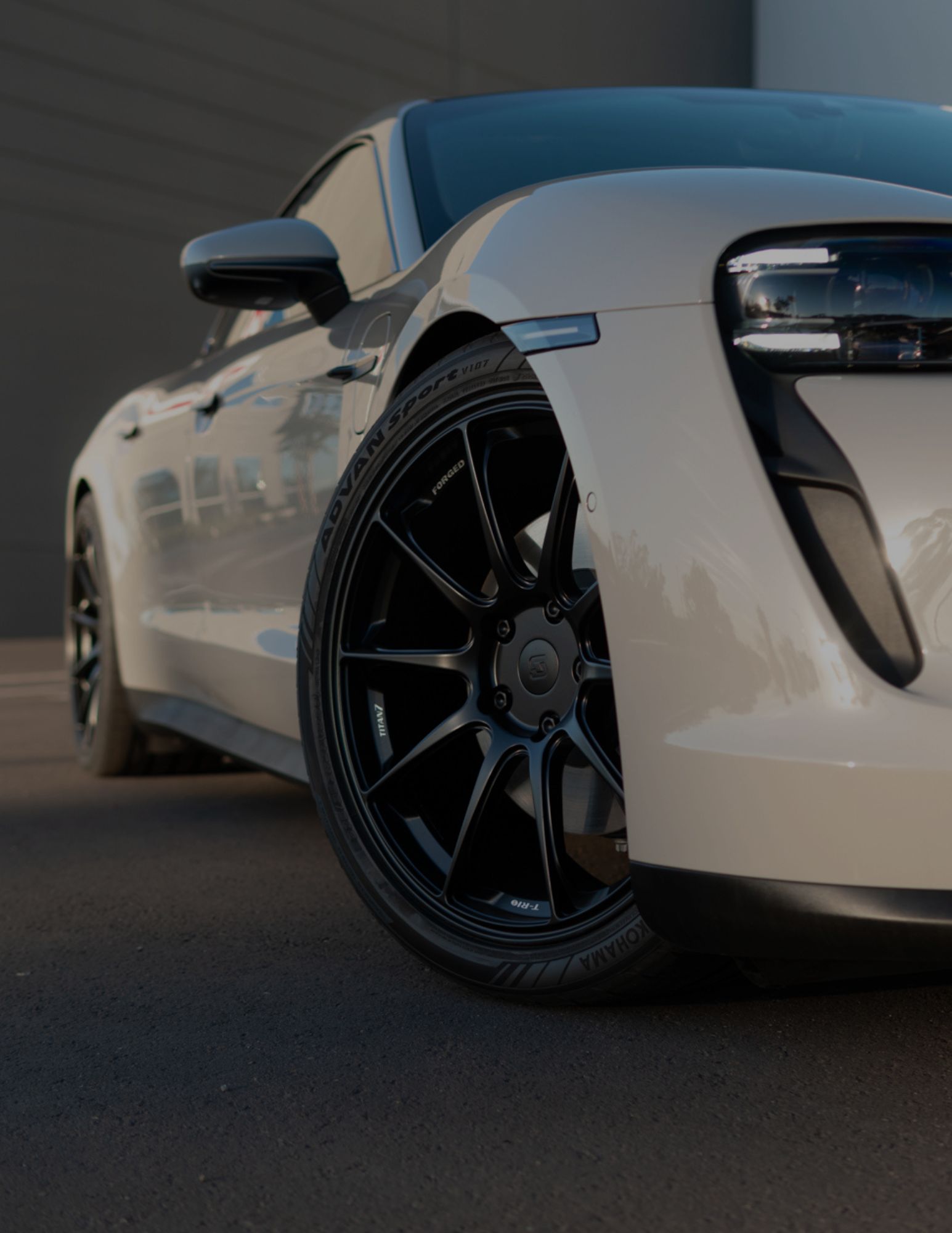 A technician rolling out matte paint protection film, preparing for installation on a vehicle's surface.