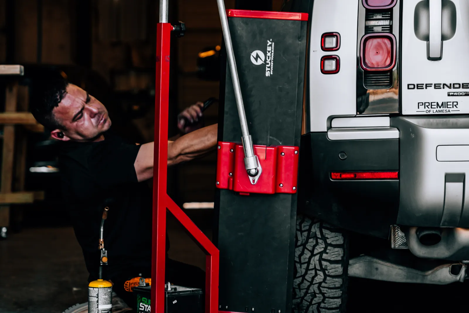 PDR technician using glue-pull tools on a Land Rover Defender at Hail Repair Pro Lubbock, TX