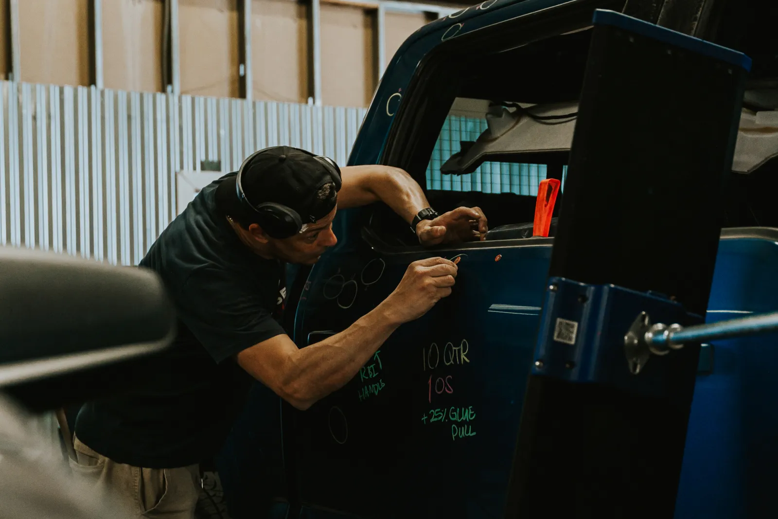 Certified paintless dent repair technician mapping hail damage on a truck door in Lubbock, TX